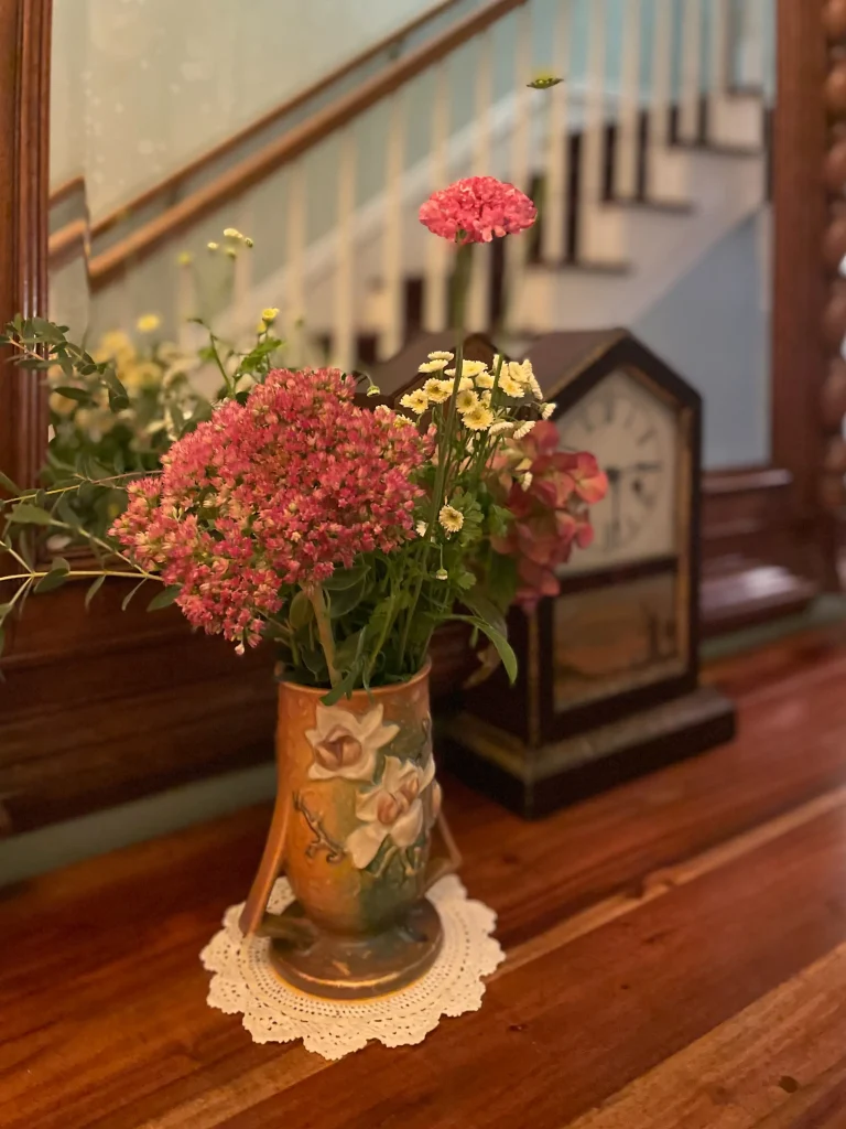 flower arrangement and antique clock in historic Jacksonville Oregon inn